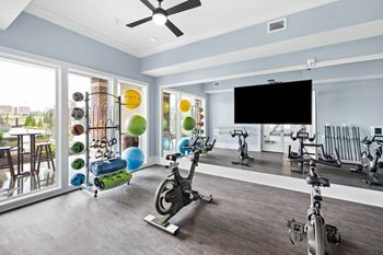 a home gym with exercise equipment and a large window